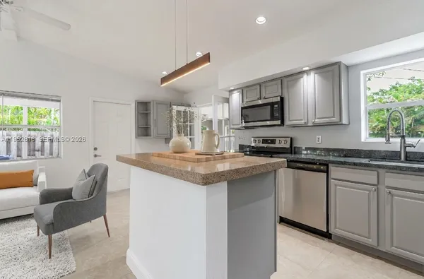 a kitchen with granite countertop a sink and a stove top oven