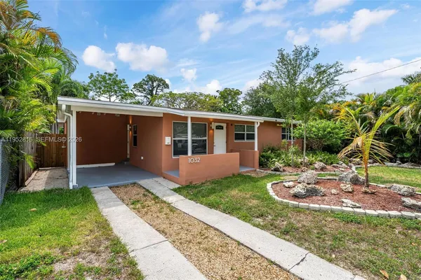 a view of a house with backyard and tree