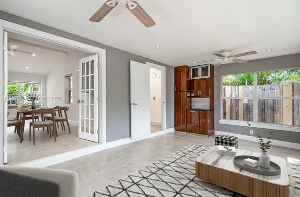 a living room with furniture a large window and stainless steel appliances
