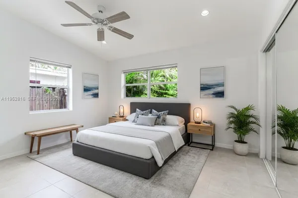 a bedroom with a large bed and a potted plant