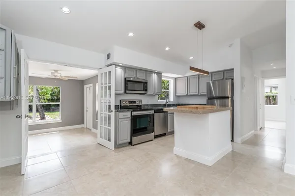 a kitchen with a refrigerator and a stove top oven