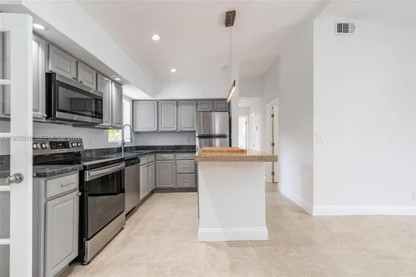a kitchen with cabinets and stainless steel appliances