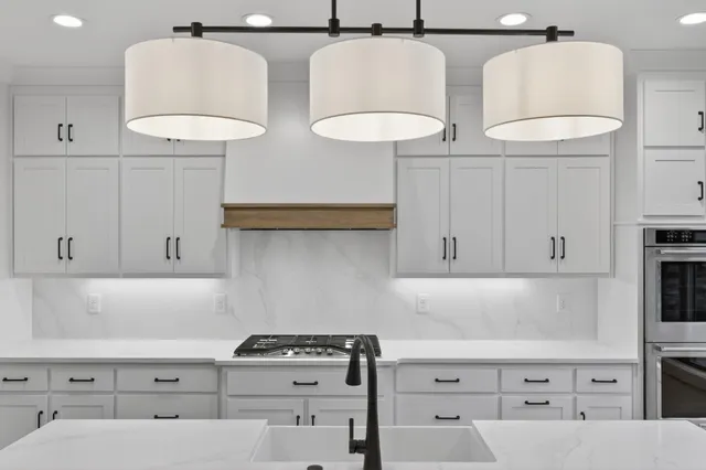 a kitchen with white cabinets stainless steel appliances and a counter space