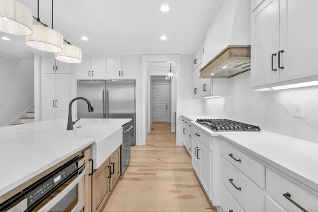 a kitchen with stainless steel appliances granite countertop a sink and a refrigerator
