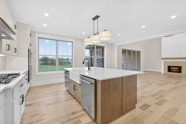a bedroom with a large bed and a chandelier next to a window