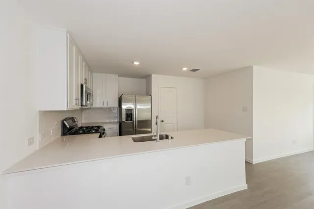 a view of a kitchen with a sink and a refrigerator