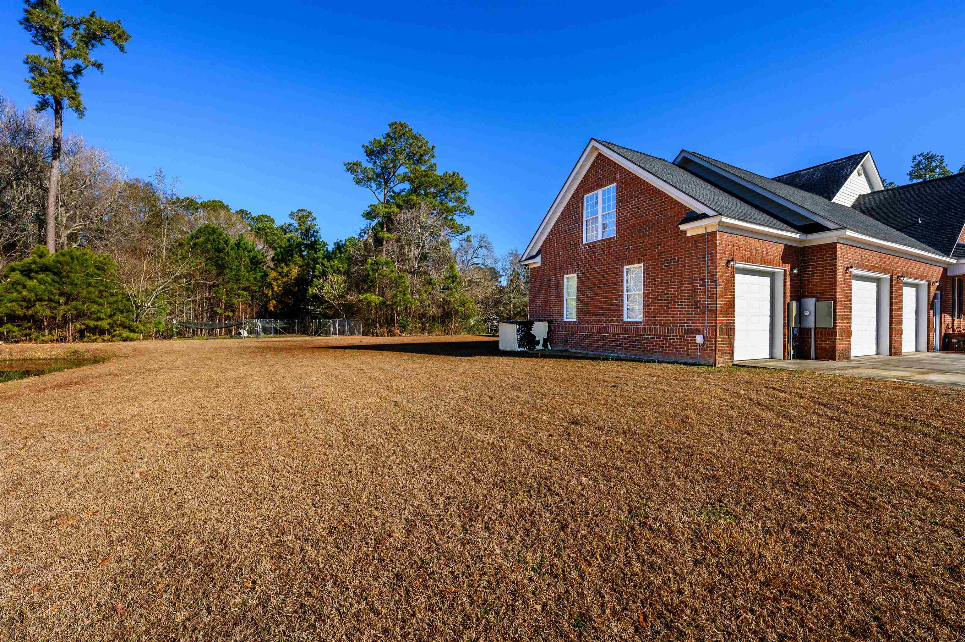 4310 Enoch Road Aynor, SC 29511 - Photo 39 of 39 View of property exterior featuring brick siding, a lawn, concrete driveway, and an attached garage