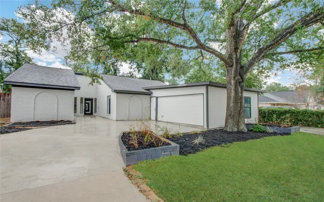 a front view of a house with a garden and yard