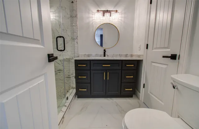 a bathroom with a sink a toilet and shower