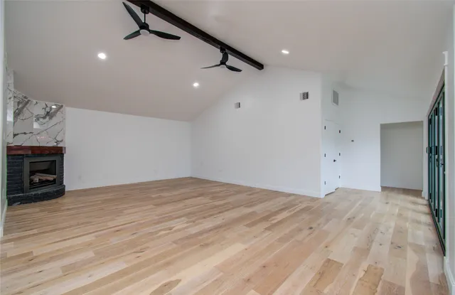 a view of empty room with wooden floor and ceiling fan