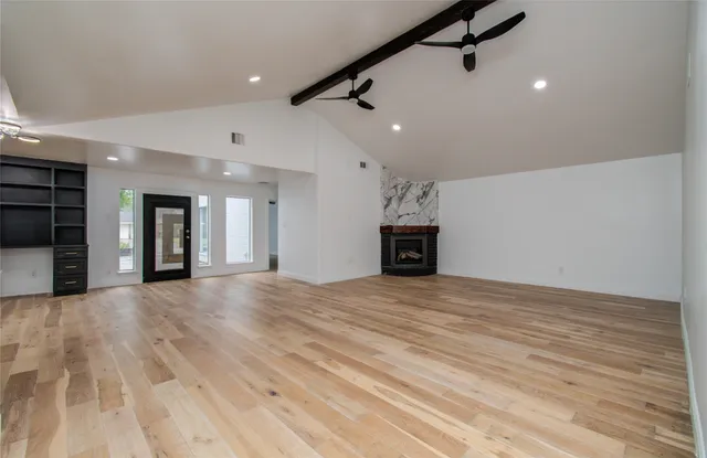 a view of empty room with wooden floor and fireplace