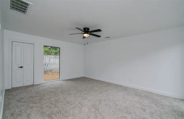 a view of an empty room with a ceiling fan