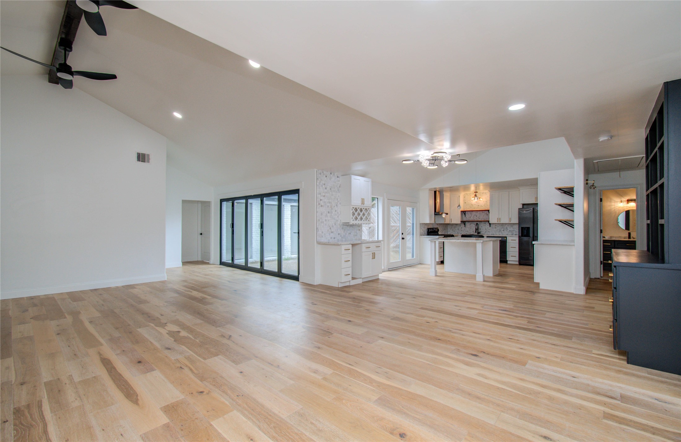 10300 Mayfield Road Houston, TX 77043 - Photo 3 of 32 a view of an empty room and kitchen with wooden floor