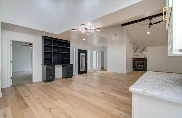 a view of an empty room with a kitchen and a window