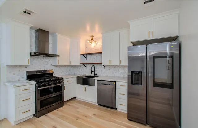 a kitchen with white cabinets and stainless steel appliances