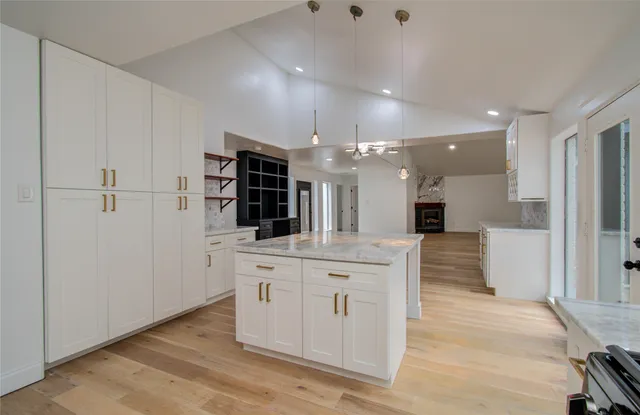 a kitchen with stainless steel appliances kitchen island granite countertop a refrigerator and a sink