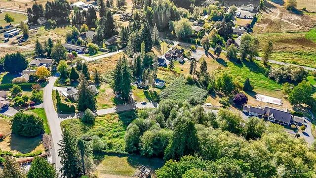 an aerial view of a residential houses with yard