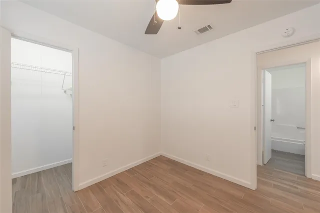 a view of an empty room with wooden floor