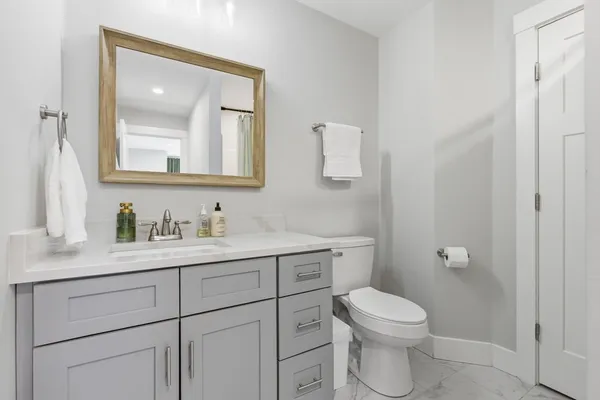 a bathroom with a toilet a sink a vanity and mirror