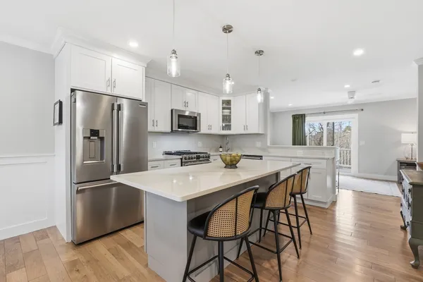 a kitchen with stainless steel appliances a refrigerator a stove a sink a dining table and chairs