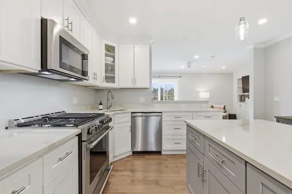 a kitchen with stainless steel appliances granite countertop a sink stove oven a sink dishwasher and cabinets with wooden floor