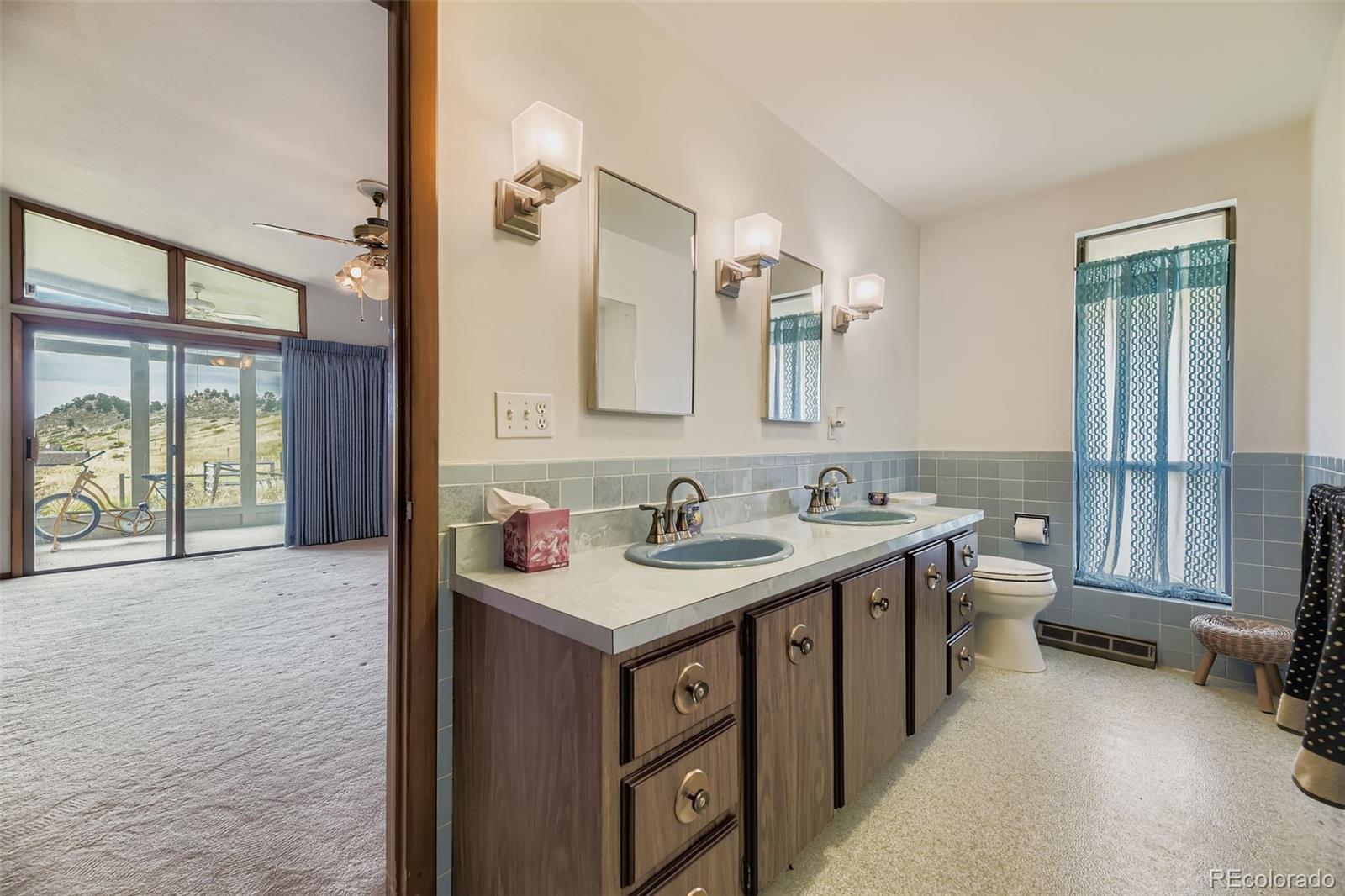 5040 Pine Ridge Road Golden, CO 80403 - Photo 23 of 41 a bathroom with a sink a toilet and a mirror