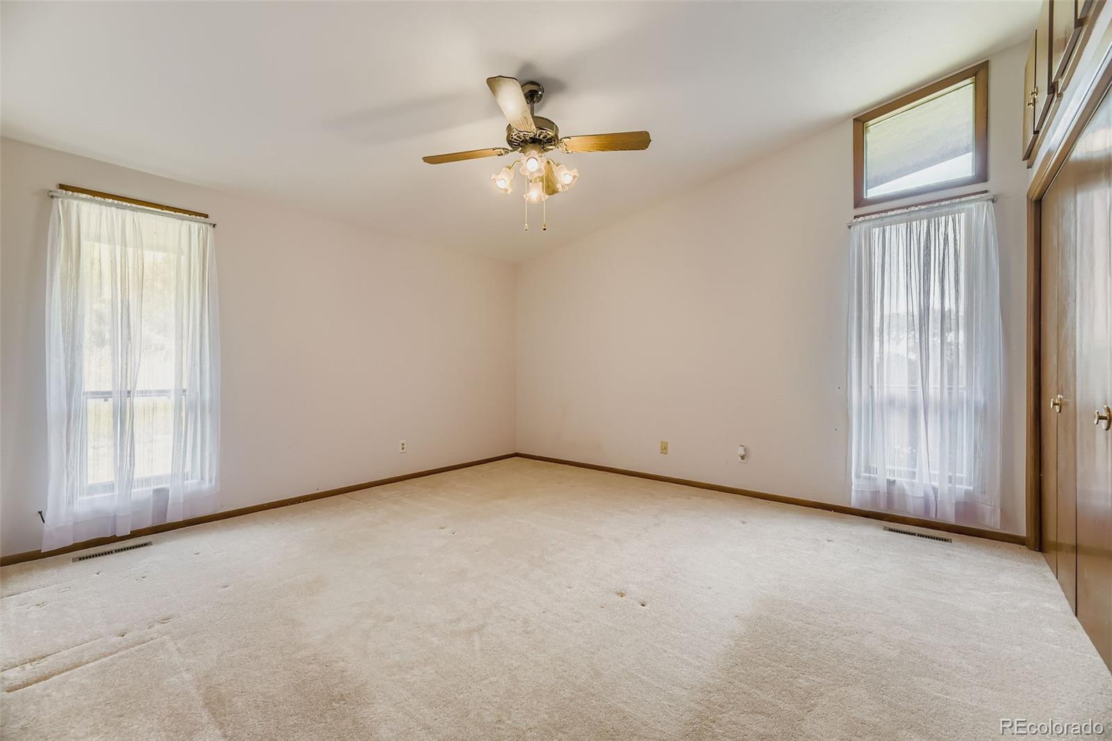 5040 Pine Ridge Road Golden, CO 80403 - Photo 25 of 41 an empty room with windows and ceiling fan view