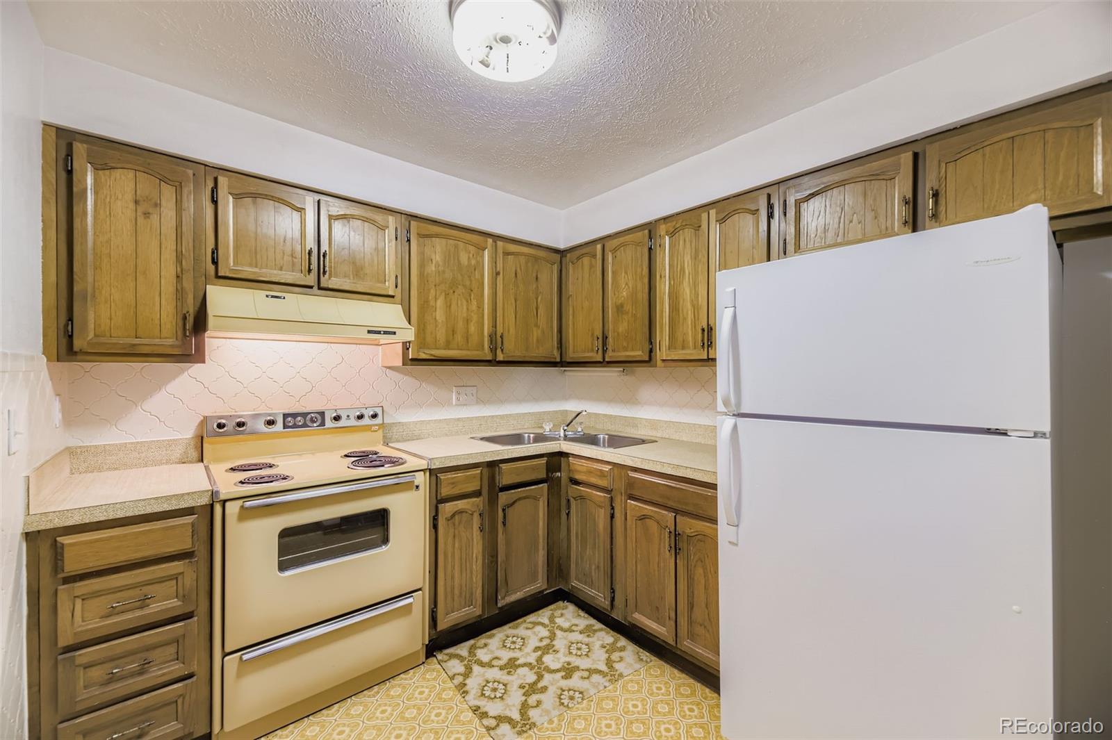5040 Pine Ridge Road Golden, CO 80403 - Photo 31 of 41 a white refrigerator freezer sitting inside of a kitchen with stainless steel appliances granite countertop cabinets and a refrigerator