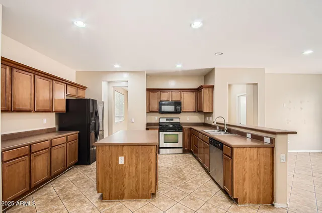 a kitchen with stainless steel appliances granite countertop a stove a sink dishwasher a refrigerator and a oven