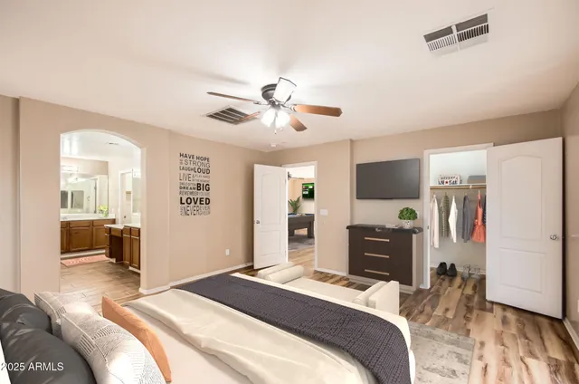 a bedroom with a bed desk and a chandelier