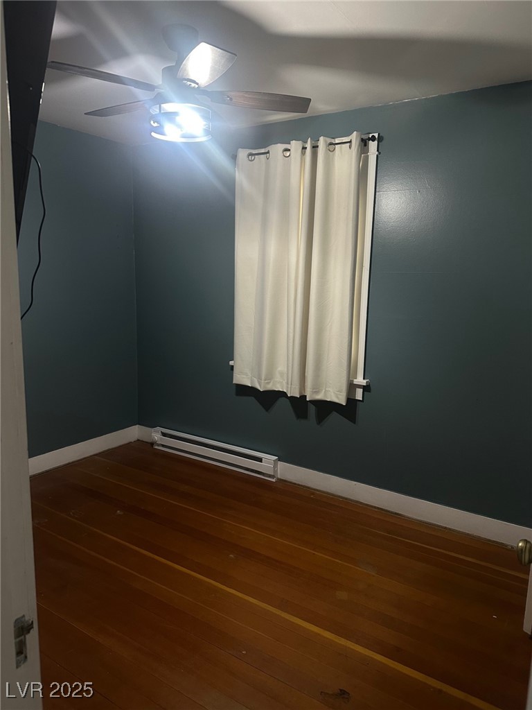 966 Mill Street Ely, NV 89301 - Photo 11 of 14 Bedroom with dark wood-style flooring, baseboard heating, and ceiling fan