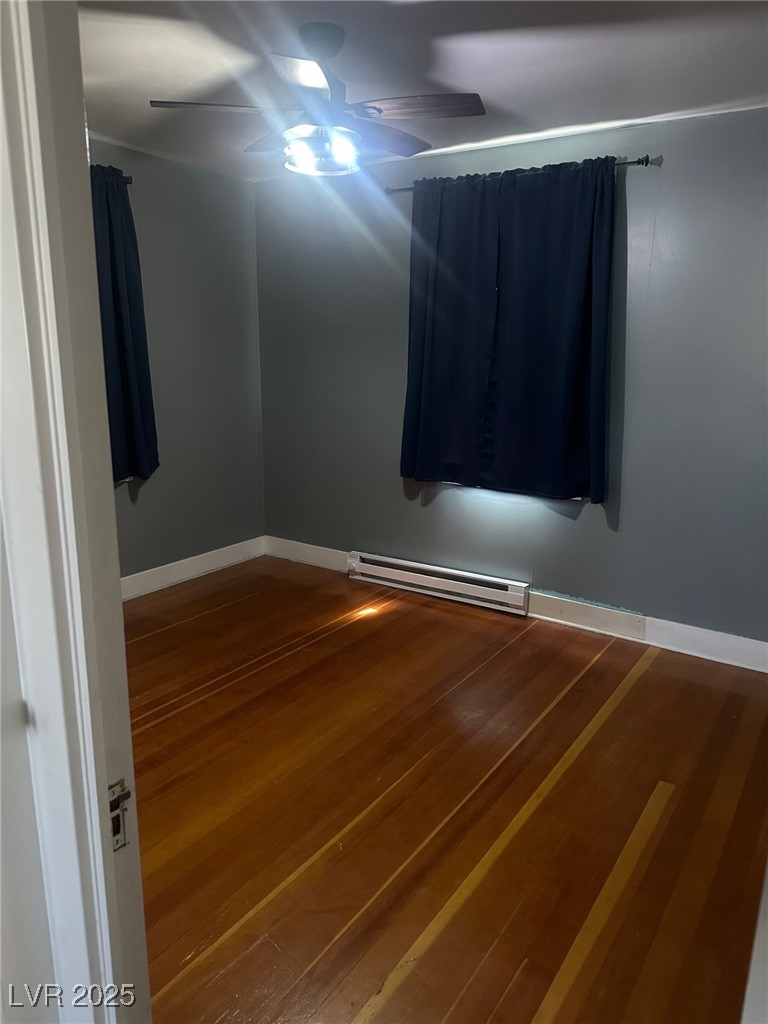 966 Mill Street Ely, NV 89301 - Photo 7 of 14 Spare room with hardwood / wood-style flooring, baseboard heating, and a ceiling fan