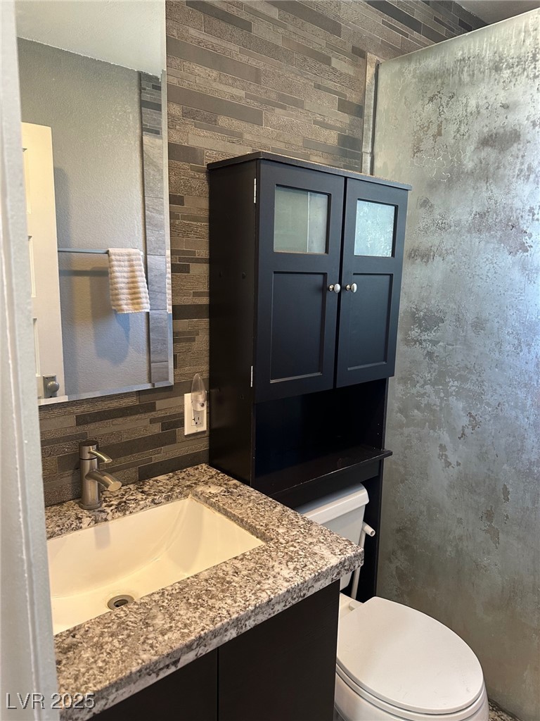 966 Mill Street Ely, NV 89301 - Photo 8 of 14 Full bath featuring vanity, a shower stall, and decorative backsplash