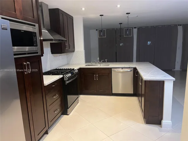 a kitchen with stainless steel appliances granite countertop a sink and a stove