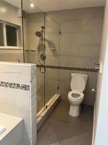 a bathroom with a toilet and a shower