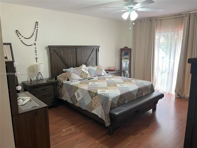 a bed sitting in a bedroom next to a window and a chandelier