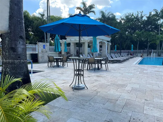 a view of a patio with chairs and table under an umbrella