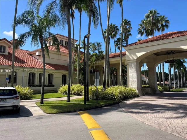 a view of a house with a yard and palm trees