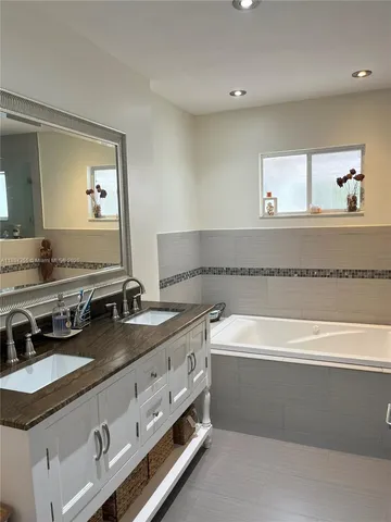 a bathroom with a granite countertop double vanity sink and a mirror