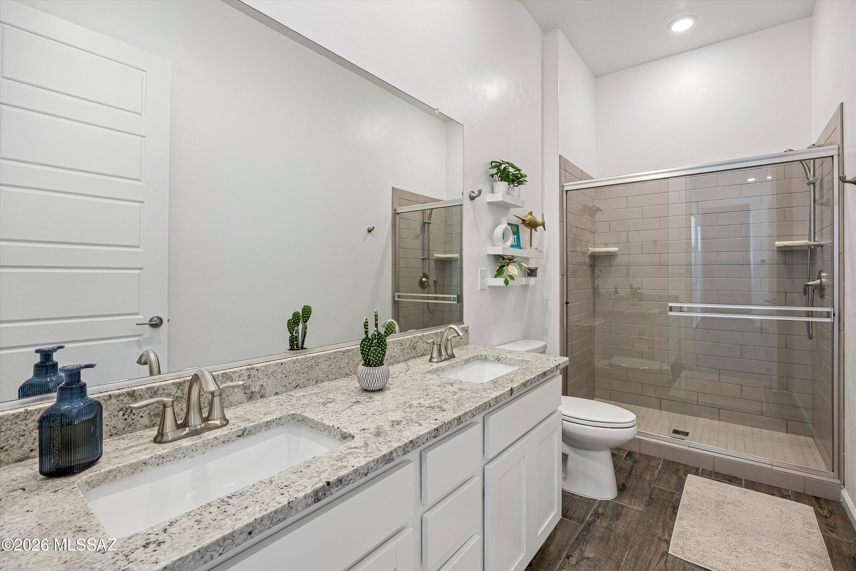 5196 West Ridgemont Court Tucson, AZ 85742 - Photo 32 of 46 Guest bathroom #1 with double vanity, walk in shower with glass enclosure, and granite countertop