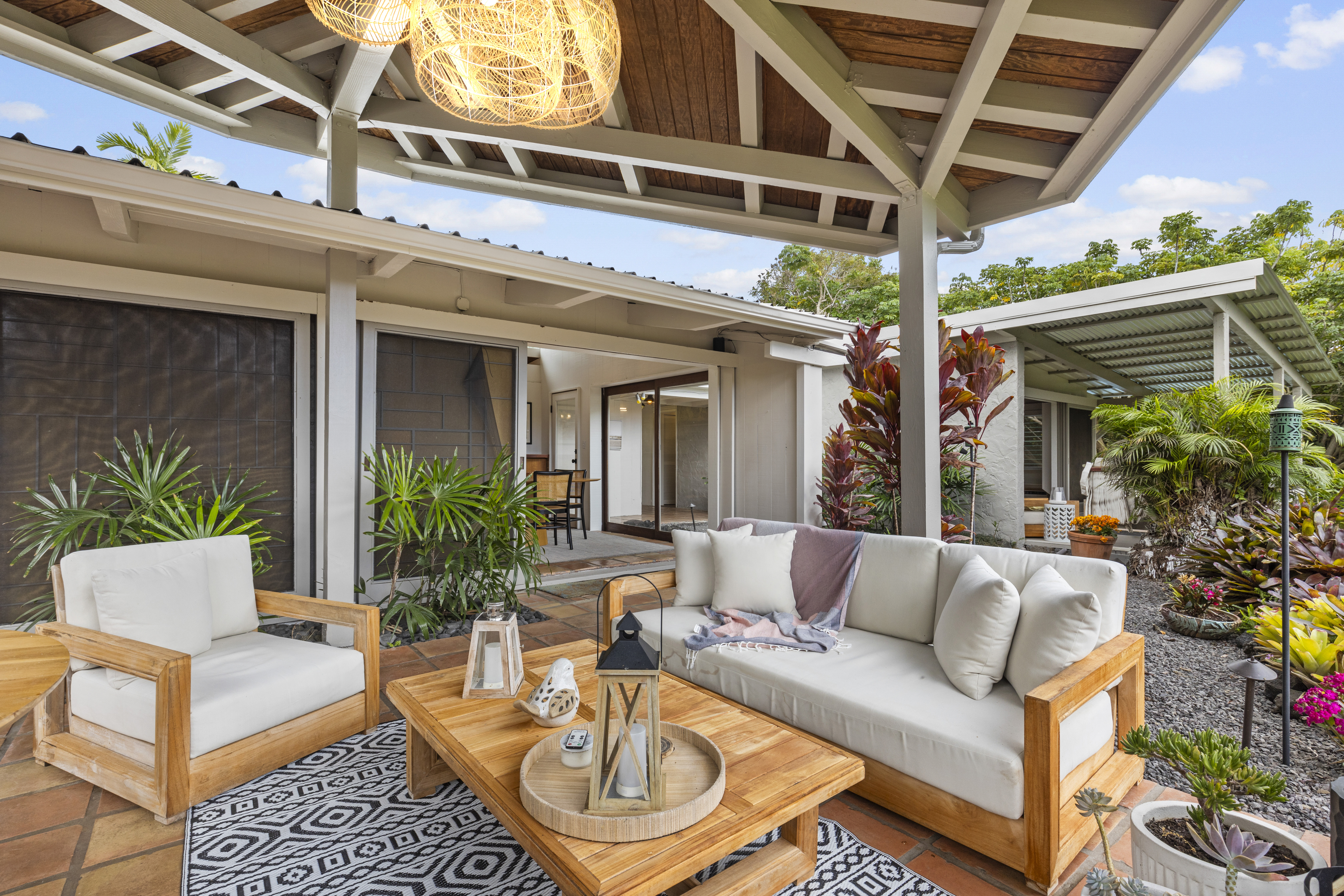 83-5369 Manako Road Captain Cook, HI 96704 - Photo 12 of 30 a view of a patio with couches table and chairs and potted plants