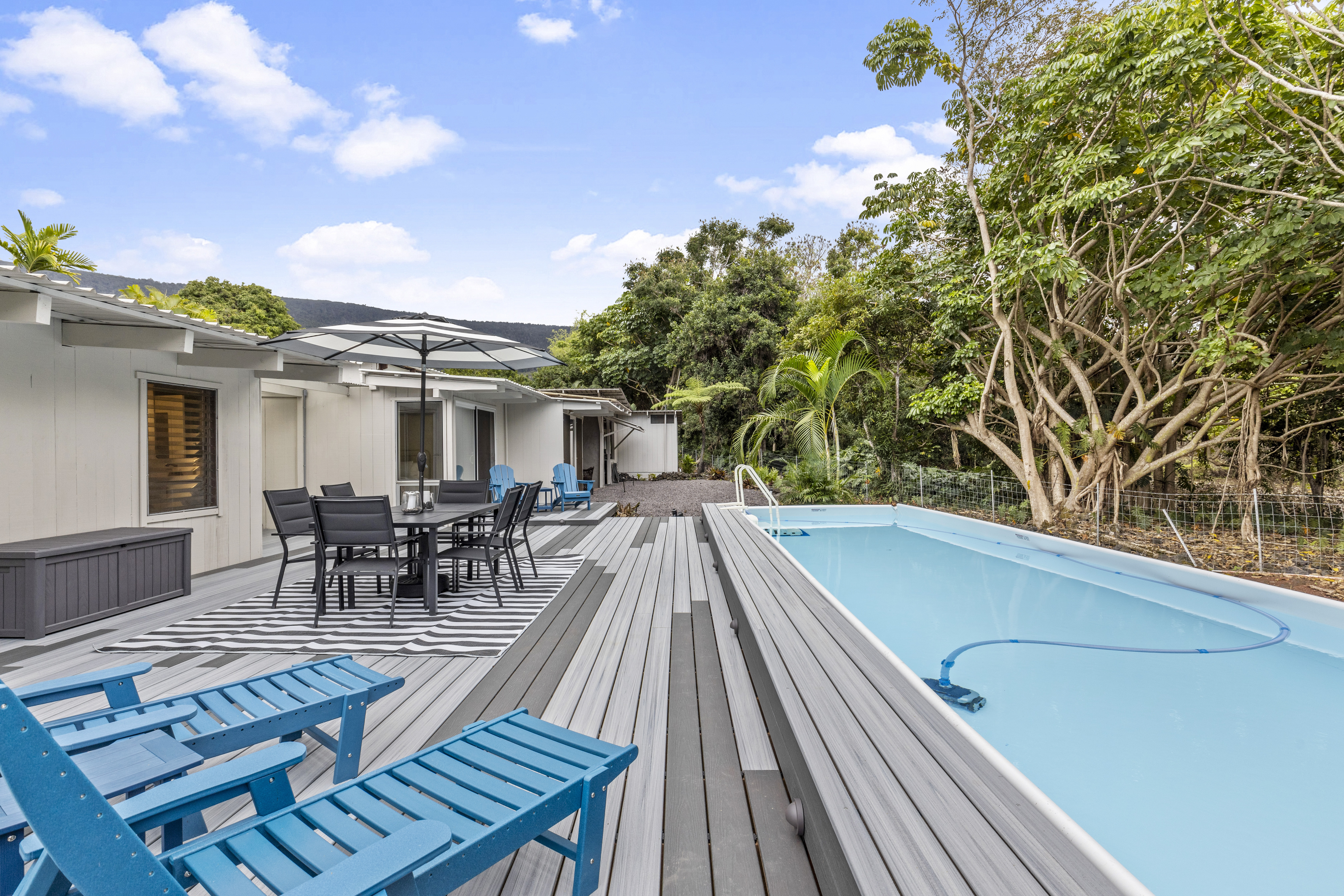 83-5369 Manako Road Captain Cook, HI 96704 - Photo 22 of 30 a view of a patio with table and chairs and potted plants with wooden floor