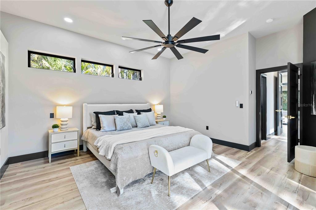 4534 Banan Place Siesta Key, FL 34242 - Photo 33 of 77 a bedroom with a large bed and a chandelier