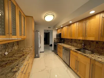 a metallic refrigerator freezer sitting in a kitchen
