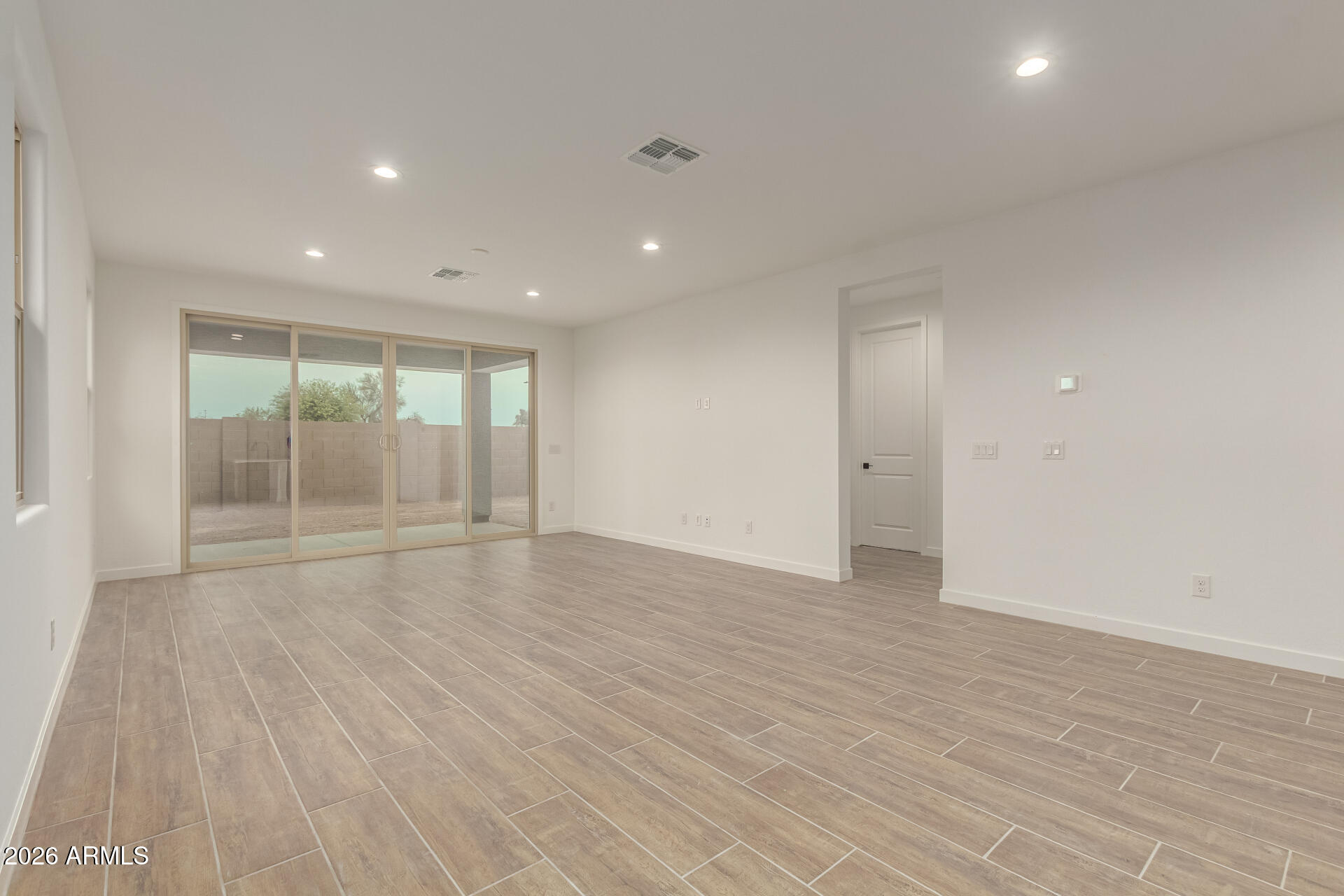8030 West Granada Road Phoenix, AZ 85035 - Photo 5 of 36 a view of an empty room with wooden floor and a window