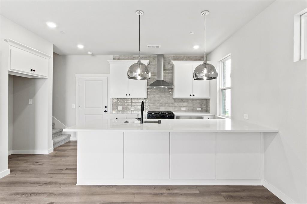 2020 Aldrich Road Celina, TX 75009 - Photo 13 of 40 a large white kitchen with a large island oven a sink stainless steel appliances and cabinets