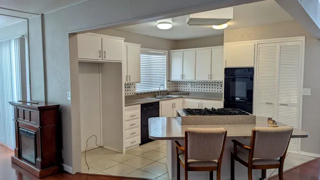 a kitchen with stainless steel appliances kitchen island granite countertop a stove a sink and a refrigerator