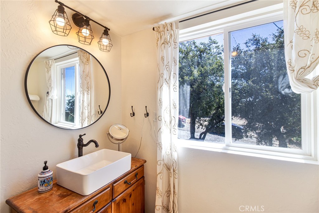 24387 Rocky Point Road Idyllwild, CA 92549 - Photo 9 of 29 a bathroom with a sink a mirror and a shower
