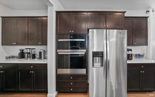 a kitchen with stainless steel appliances granite countertop a sink a stove and a wooden floors