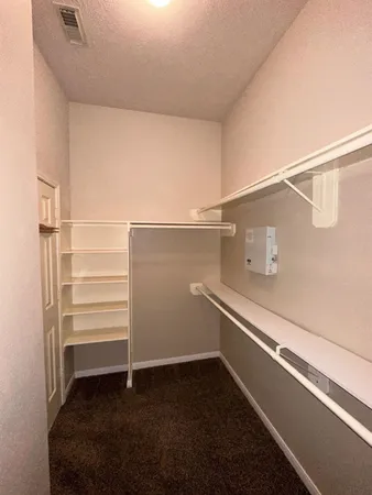 an empty room with a chandelier fan and windows